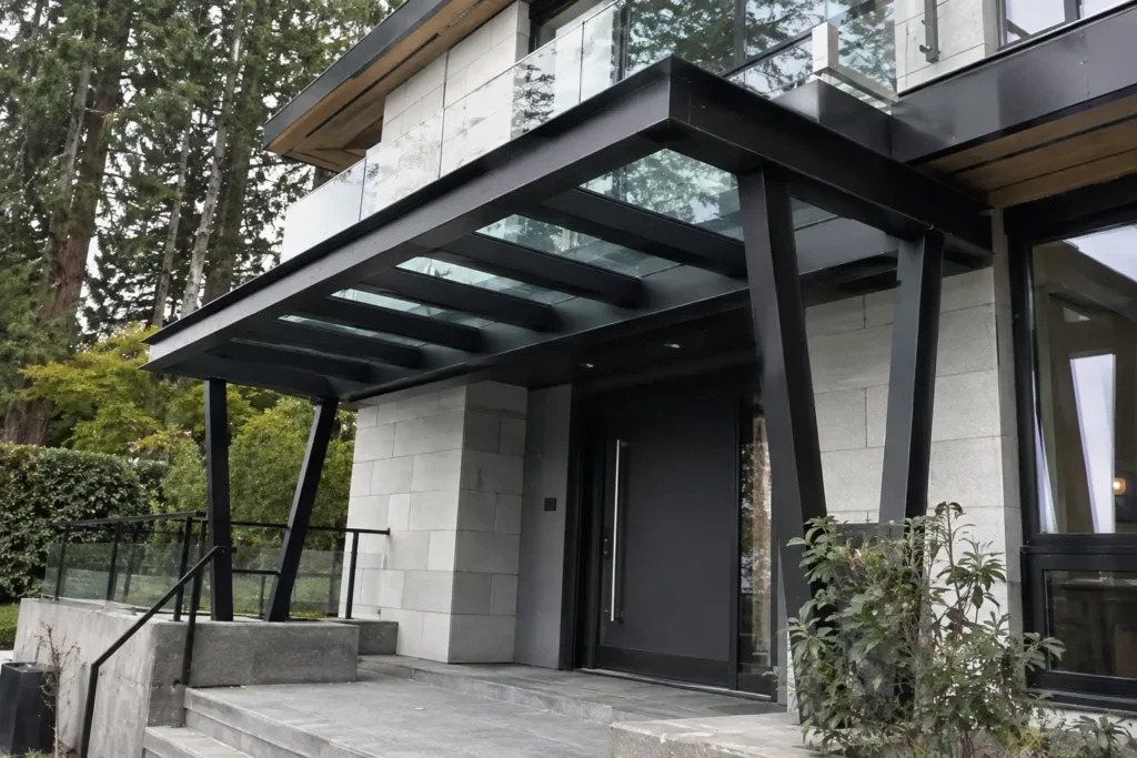 Structural steel entrance canopy with glass roof at a modern West Vancouver residence